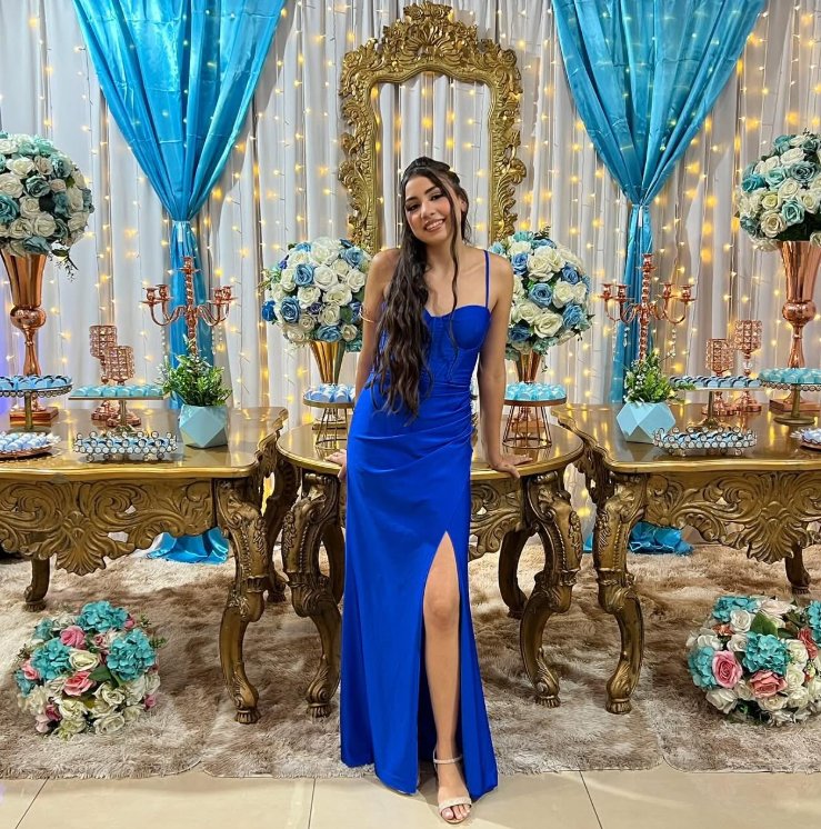 Debutante de vestido azul em frente à mesa decorada