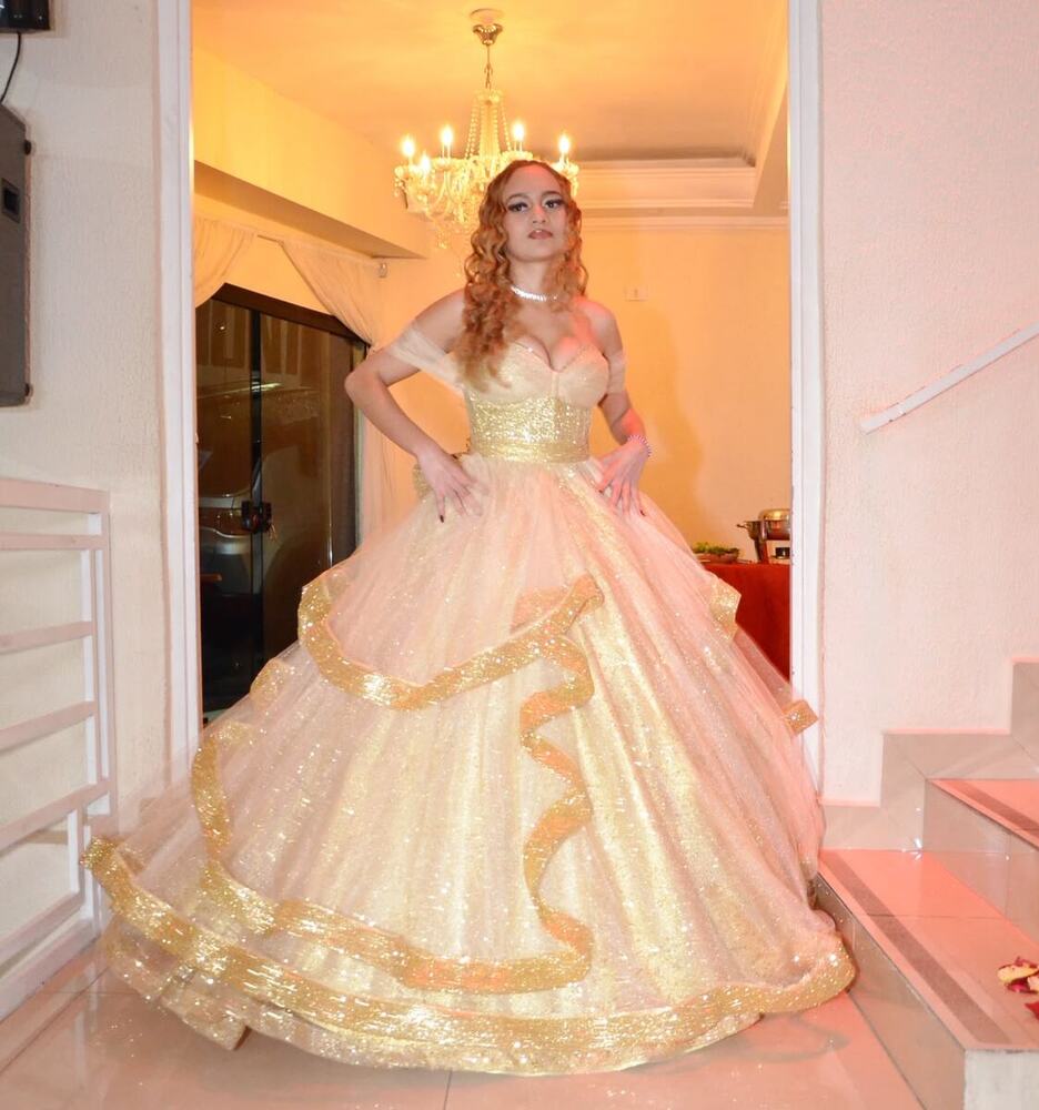 Debutante de vestido champanhe na entrada do salão