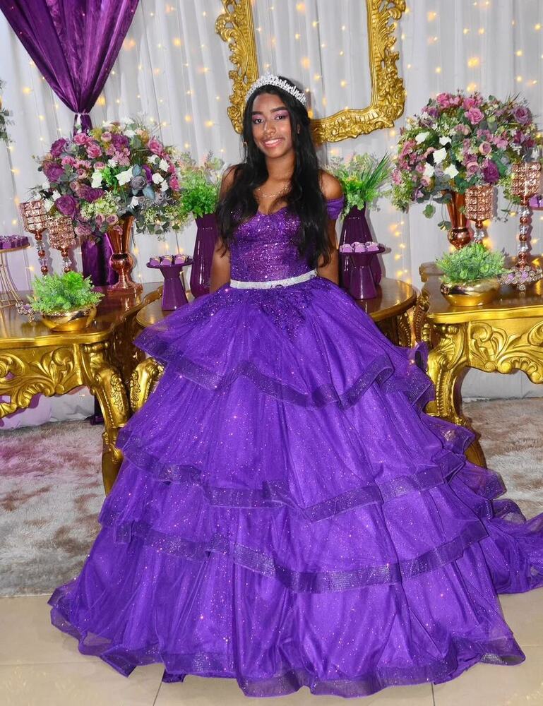 Debutante de roxo em frente à mesa principal