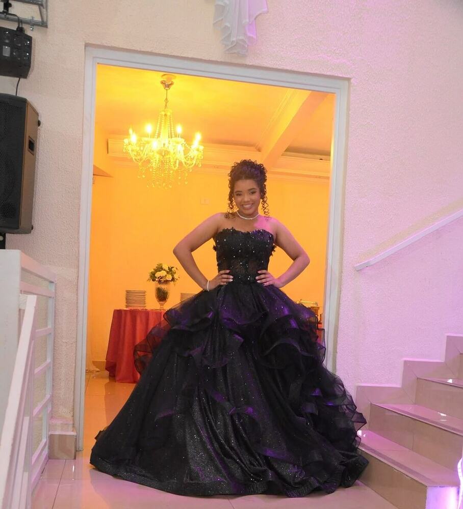 Debutante de preto na porta iluminada