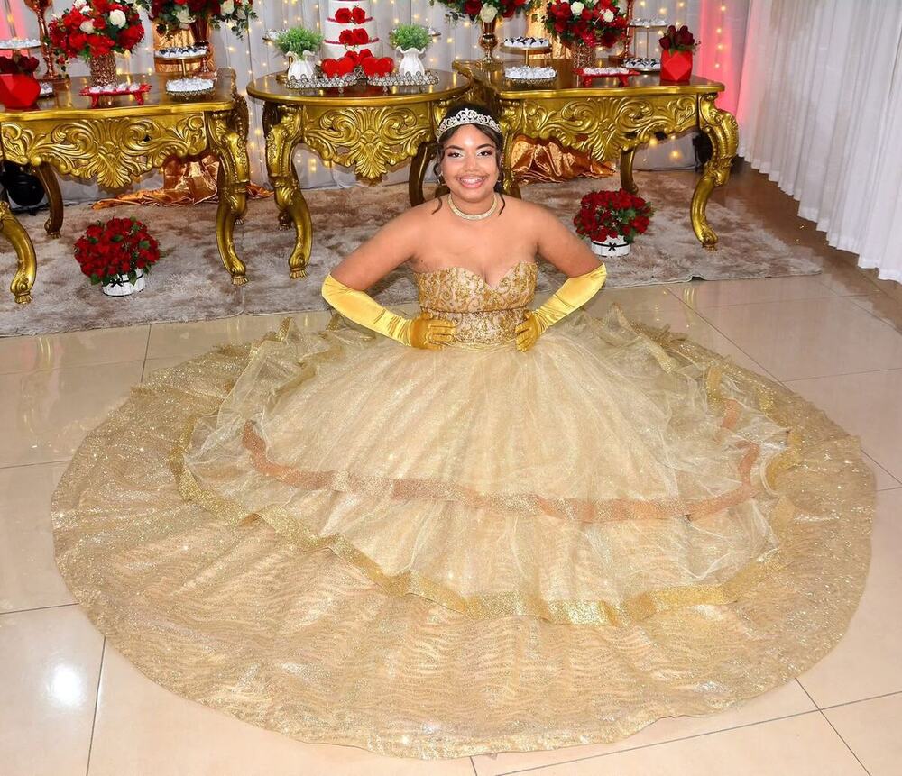 Debutante de vestido dourado sentada no salão